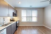 Located at 2232 S 64th Ave in Omaha, Nebraska, this efficiently designed single-floor unit offers a thoughtfully arranged layout that maximizes its intimate footprint. The open living area is bathed in natural light from a large window fitted with horizontal blinds, and is complemented by warm hardwood-style flooring and neutral-toned walls that create a bright, welcoming ambiance. A ceiling fan adds comfort and airflow to the space.

The kitchen is a functional highlight, showcasing dark wood-grain cabinetry paired with crisp white countertops and a full suite of stainless steel appliances, including a refrigerator, dishwasher, electric range, and over-the-range microwave. The clean lines and modern finishes give the kitchen a contemporary, polished look.

The bathroom continues the modern aesthetic with a wood-toned vanity, white countertop, large mirror, and light ceramic tile flooring. Clean white panel doors and ample towel storage contribute to its organized and practical design.

Throughout the unit, consistent use of neutral tones, white trim, and hardwood-style flooring creates a cohesive and move-in-ready environment. This space is ideal for those seeking a compact yet modern and well-equipped residence in a convenient Omaha location.