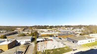 Situated on Foster Street in the heart of Durham, North Carolina, this single-story space offers a practical and well-positioned setting within a vibrant urban commercial corridor. The surrounding area reflects the dynamic character of Durham's evolving cityscape, with a mix of commercial buildings, parking facilities, and local businesses visible from the property. The location benefits from strong visibility and accessibility, placing it within easy reach of the broader Durham community. The aerial perspective reveals an open, flat roofline consistent with functional commercial architecture, set against a backdrop of mature trees lining the neighborhood perimeter and an expansive Carolina blue sky. The area's established infrastructure, including paved lots and road access, supports a variety of business uses. Whether utilized as a retail, office, or service-oriented space, this Foster Street property delivers a straightforward, single-level layout in a well-connected Durham location, making it a compelling option for those seeking a presence in one of North Carolina's most growing and energetic cities.