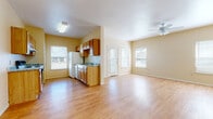 This single-floor unit offers a practical and comfortable layout designed for everyday living. The open-concept living area is bright and airy, featuring warm-toned hardwood-style flooring, neutral walls, and multiple windows that invite generous natural light. A ceiling fan keeps the space comfortable, while a front entry door with a sidelight panel provides an inviting entrance.

The kitchen is a standout feature, designed in a galley configuration with ample cabinetry in warm wood tones lining both sides. Granite-style countertops provide functional workspace, and the kitchen is equipped with a full suite of appliances including an electric range, refrigerator, and dishwasher. A window at the end of the galley adds natural light to the cooking area.

The bedrooms are well-sized, each featuring the same hardwood-style flooring, neutral walls, and ceiling fans that echo the rest of the unit. Large windows offer views of the surrounding greenery, filling each room with natural light.

The bathrooms are clean and efficiently laid out, each featuring a full tub-and-shower combo, wood-tone cabinetry for storage, and the same consistent wood-style flooring found throughout the unit. The overall aesthetic is cohesive, functional, and move-in ready.