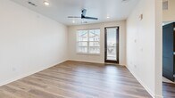 Located at 1200 Duff Dr in Fort Collins, Colorado, this well-appointed one-bedroom, one-bathroom unit offers a thoughtfully designed layout with contemporary finishes throughout. The open-concept kitchen and living area forms the heart of the home, anchored by warm wood-toned cabinetry, a white subway tile backsplash, stainless steel appliances including a refrigerator, range, and built-in microwave, and a granite-topped island with an undermount sink — ideal for both cooking and casual dining. Recessed lighting and a ceiling fan keep the living space bright and comfortable, while hardwood-style flooring flows seamlessly throughout the main living areas. A glass-paneled door opens to an outdoor area, inviting natural light and neighborhood views into the room. The bedroom is generously sized, featuring plush carpeting, a ceiling fan, and a large window overlooking the surrounding community. A double-door closet provides ample storage. The bathroom continues the modern aesthetic with wood-finish cabinetry, a granite countertop, an undermount sink, and wood-look flooring. A connecting hallway ties the spaces together with clean, cohesive design. The unit's crisp white walls and neutral tones create a fresh, move-in-ready atmosphere throughout.