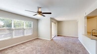 Located at 3405 Calle Cuervo NW in Albuquerque, New Mexico, this two-bedroom, one-bathroom unit offers a thoughtfully laid-out single-floor plan. The kitchen is a standout feature, outfitted with stainless steel appliances including a refrigerator, gas range, and microwave, complemented by white cabinetry, granite countertops, and a peninsula with a built-in sink. Wood-look flooring runs through the kitchen and bathroom, lending a clean, cohesive aesthetic. Both bedrooms are carpeted and feature ceiling fans with light fixtures. The primary bedroom benefits from natural light through multiple windows and includes a bifold closet for convenient storage. The second bedroom is cozy and well-proportioned, with easy access to the shared hallway. The bathroom is finished with classic white subway tile in the tub/shower surround, wood-look flooring, and brushed nickel fixtures. A dedicated laundry area houses a full-size top-load washer with an overhead shelf, adding everyday convenience. Neutral-toned walls throughout create a calm, versatile backdrop. The overall layout is efficient and functional, making excellent use of the available space.