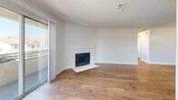 Located at 6701 Del Rey Ave in Las Vegas, NV, this single-level 3-bedroom, 2-bathroom residence offers a thoughtfully designed layout with consistent wood-style flooring flowing throughout every room. The open-concept living area is anchored by a classic white-mantled fireplace and features a textured ceiling, neutral tones, and access to a private balcony that brings in abundant natural light.

The kitchen is a standout feature, boasting white shaker cabinets, dark lower cabinetry, stainless steel appliances including a refrigerator, range, and microwave, a white quartz peninsula with an undermount sink, and recessed lighting overhead. The peninsula provides additional seating and workspace, seamlessly connecting the kitchen to the living area.

Each of the three bedrooms is bright and well-proportioned, with large windows fitted with blinds offering outdoor views and natural light. Bedrooms include built-in sliding closets with paneled doors for ample storage. The dedicated closet space adds further organizational convenience.

Both bathrooms are clean and functional, featuring tub-shower combos, white surrounds, wood-style flooring, light countertops, and stylish vanities—one with a navy blue cabinet. The overall ambiance is fresh, modern, and move-in ready.