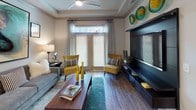 This single-floor residence showcases a thoughtfully designed open layout that balances style and functionality across every room. The kitchen is a standout feature, outfitted with white shaker-style cabinetry, granite countertops, a subway tile backsplash, stainless steel appliances including a range, over-the-range microwave, and refrigerator, plus a large central island with pendant lighting — ideal for both meal prep and casual dining. Wood-look flooring flows through the main living areas, anchoring the spacious living room, which benefits from natural light through full-length French doors and features a tray ceiling with a ceiling fan. The bedrooms are generously proportioned with plush carpeting, large windows, and ample closet space, including a walk-in closet in the primary bedroom. Two well-appointed bathrooms mirror the home's refined aesthetic, each offering white cabinetry with ample storage, granite countertops, large framed mirrors, and wood-look tile flooring. One bathroom includes a glass-enclosed shower, while the other features a shower-tub combination. Neutral wall tones throughout create a versatile, inviting ambiance that complements the home's contemporary design details.