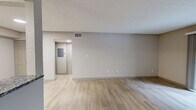 Located at 5000 S Lincoln Trace Ave SE in Smyrna, GA, this one-bedroom, one-bathroom unit offers a practical and well-appointed layout across a single floor. Light hardwood-style flooring runs throughout the space, lending a clean, cohesive aesthetic to every room.

The combined kitchen and living area serves as the heart of the unit. The galley-style kitchen is equipped with stainless steel appliances, including a range and refrigerator, complemented by granite countertops, white shaker cabinetry, and a classic white subway tile backsplash. A skylight provides additional natural light overhead. The adjacent living area is open and airy, with neutral walls and a sliding glass door that leads to a private balcony overlooking a lush, wooded outdoor setting.

The bedroom is a comfortable, well-proportioned space featuring a ceiling fan with light fixture, a window that brings in natural light, and textured ceilings. A dedicated closet provides ample storage. The hallway connects the main living areas to the bedroom and bathroom efficiently.

The bathroom features granite countertop vanity, a full tub-shower combination with clean white tile surround, and wood-style flooring consistent with the rest of the unit. The overall ambiance throughout is bright, neutral, and move-in ready.