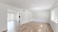 Located at 1075 N Hairston Rd in Stone Mountain, GA, this two-story home offers 2 bedrooms and 3 bathrooms across two well-proportioned floors. The main level features two open living areas filled with natural light, showcasing clean white walls, wood-look luxury vinyl flooring, and textured ceilings throughout. The galley-style kitchen is outfitted with white shaker cabinets, black hardware accents, marble-look countertops, and stainless steel appliances including an electric range and refrigerator. A dedicated laundry room on the lower level includes washer and dryer hookups and a water heater. The upper level hosts the bedrooms, including a spacious primary bedroom with a large window, double closets, and direct access to a private bathroom. The second bedroom also features a closet and ample natural light. All three bathrooms are finished consistently with wood-look flooring, white fixtures, tub-shower combinations, and sleek black hardware. A staircase connects both floors, with a hallway providing easy access to all upper-level rooms. The home's cohesive design, neutral color palette, and functional layout make it a well-organized and move-in ready residence.