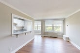Located in Washington, DC's Connecticut Avenue corridor, this well-appointed one-bedroom, one-bathroom residence offers a thoughtfully designed layout across a single floor. The open combined living and dining area is a standout, featuring warm hardwood flooring, elegant crown molding, and large windows that flood the space with natural light and frame lush, tree-lined views. The updated kitchen connects seamlessly to the living area via a pass-through counter and features granite countertops, white shaker cabinetry, a subway tile backsplash, marble-look tile flooring, and stainless steel appliances including a gas range, refrigerator, dishwasher, and microwave. The generously sized bedroom offers dual windows with greenery views, hardwood floors, and a ceiling fan, complemented by ample closet storage — four closets total throughout the unit. The bathroom is finished with marble-look tile walls and flooring, a grey vanity with a white countertop, and a mirrored medicine cabinet. Neutral warm-grey tones carry throughout the space, creating a clean, cohesive aesthetic. A hallway provides additional separation and privacy between the living and sleeping areas, rounding out this efficient and comfortable home.