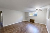 Located at 273 S Winebiddle St in Pittsburgh's Garfield neighborhood, this single-floor, 2-bedroom, 1-bathroom unit offers a practical and well-organized layout. The combined living and dining area is the heart of the home, featuring warm hardwood-style flooring, neutral gray walls, a ceiling fan with light fixture, and a pass-through window that connects directly to the kitchen — creating an open, communicative flow between the spaces. The kitchen is appointed with rich wood cabinetry, granite countertops, a stainless steel sink, a tile backsplash, and tile flooring, with a window that brings in natural light. The primary bedroom is generously sized, with hardwood-style flooring, a cast-iron radiator, a ceiling fan, and a window overlooking the exterior. The second bedroom features plush carpeting, a window with natural light, and its own cast-iron radiator. Two closets provide ample storage. The bathroom includes a full tub and shower combination with classic white subway tile surround. A connecting hallway ties all rooms together efficiently. Radiator heating is present throughout, adding a nod to the unit's classic character alongside its modern updates.