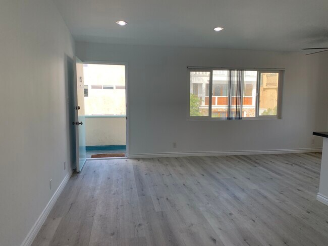 Huge open concept living room w/ wood flr and hi ceilings + lrg windows overlooking walkstreet - 320 11th St