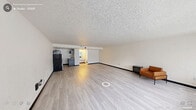 Located at 2517 Guess Rd in Durham, NC, this single-floor unit offers a practical and efficiently designed layout. The open-concept living area is the heart of the space, finished with light-toned hardwood-style flooring that runs throughout and contrasted by bold black baseboards, creating a clean, modern aesthetic. Crisp white walls keep the interior feeling bright and neutral, providing a versatile canvas for any style of furnishing.

A wide bank of floor-to-ceiling windows along one wall allows generous natural light to fill the room, complemented by vertical blinds for privacy control. A wall-mounted HVAC unit ensures year-round climate comfort. The textured popcorn ceiling adds a classic architectural detail overhead.

The kitchenette, partially separated by a structural beam, includes dark cabinetry and is equipped with a full-size refrigerator and additional countertop appliances, offering functional meal preparation space within a compact footprint.

The bathroom features a full-size soaking tub with an overhead shower, a toilet, and tile flooring — all finished in clean, neutral tones that maintain a bright and hygienic feel.

Overall, the space delivers a straightforward, low-maintenance layout well-suited for single occupancy in Durham's accessible Guess Road corridor.