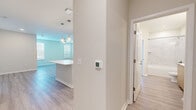 This single-story residence offers a thoughtfully designed layout across two bedrooms, two bathrooms, and three closets, delivering a comfortable and functional living environment. The open-concept kitchen and living area serves as the heart of the home, featuring light wood cabinetry, stainless steel appliances, a white quartz-topped island with pendant lighting overhead, and a white subway tile backsplash. Light wood-style flooring runs throughout the main living areas, contributing to the space's clean, contemporary aesthetic.

Both bedrooms are carpeted and equipped with ceiling fans and window blinds that allow for natural light control. The primary bedroom connects to a spacious walk-in closet outfitted with wire shelving systems for organized storage. A second walk-in closet provides additional storage capacity. The primary bathroom is notably refined, featuring a dual-sink vanity with warm wood cabinetry, white quartz countertops, large-format marble-look tile in the walk-in shower, and light wood-style flooring. A third closet adds further convenience to the layout. Neutral wall tones and consistent finishes throughout create a cohesive and modern ambiance.