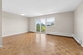 Located at 26-38 Carluke Crescent in Toronto's sought-after M2L neighbourhood, this two-bedroom, one-bathroom unit offers a well-organized single-floor layout with a functional and comfortable flow throughout. Warm parquet flooring runs consistently through the living areas and bedrooms, adding a classic character to the space.

The open living room is generously sized, bathed in natural light through large sliding glass doors that lead to a balcony, offering appealing views of the surrounding greenery and city skyline. Baseboard heating units are present throughout, ensuring year-round comfort.

The kitchen has been renovated with dark wood cabinetry extending to the ceiling for ample storage, marble-patterned countertops, a double stainless steel sink with a white subway tile backsplash, and stainless steel appliances including a refrigerator. Light tile flooring completes the clean, modern aesthetic.

The primary bedroom is a well-proportioned room featuring a window with views of the cityscape and surrounding trees. The second bedroom is a comfortable size with neutral tones and parquet flooring. The bathroom is finished in a crisp white palette with tile flooring, a full bathtub with shower, toilet, and a dark wood vanity with a white countertop. A hallway connects all rooms efficiently, rounding out this practical and inviting unit.