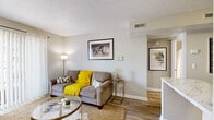 Located at 805 Bradyville Pike in Murfreesboro, Tennessee, this one-bedroom, one-bathroom unit offers a well-organized single-floor layout that makes efficient use of its space. The living room greets you with warm hardwood-style flooring, a textured ceiling, and a large sliding glass door framed by sheer drapes that fill the room with natural light. The entry area features a welcoming foyer that flows naturally into the main living space. The galley-style kitchen is a standout, equipped with rich dark wood cabinetry, light granite-style countertops, a white subway tile backsplash, and a full suite of stainless steel appliances including a refrigerator, range, and microwave. A dedicated laundry area is conveniently accessible from the kitchen corridor. The bedroom is carpeted for comfort and includes access to a walk-in closet with built-in shelving, as well as direct access to the bathroom. The bathroom features a full tub and shower combination with clean white finishes. Neutral gray tones throughout the unit create a calm, cohesive aesthetic that complements the space's practical and functional design.