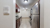 Located at 1267 11th Ave SW in Forest Lake, MN, this single-floor, 3-bedroom, 1-bathroom unit offers a practical and comfortable layout. The galley-style kitchen is a standout feature, equipped with stainless steel appliances including a refrigerator, range, microwave, and dishwasher, complemented by rich dark-cherry cabinetry and dark granite-look countertops. Light tile flooring runs throughout the kitchen, which also benefits from a ceiling fan for added comfort. The living areas are carpeted and open in feel, with ceiling fans providing airflow. The generously sized primary bedroom features a sliding glass door that lets in natural light and offers views of the surrounding greenery, along with a wall-mounted A/C unit and baseboard heating. The additional bedrooms are well-proportioned with carpeted floors, baseboard heating, and windows that bring in natural light and outdoor views. The bathroom is clean and functional, featuring a full tub and shower combination with accessibility grab bars and tile flooring. A connecting hallway ties the layout together efficiently. The textured ceilings and warm wood trim throughout lend a consistent, cohesive look to the entire unit.