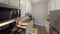 Located at 4109 Gardner Ridge Dr in Gastonia, NC, this single-floor residence offers a well-organized and functional layout throughout. The flooring is consistent dark hardwood-style planking that runs through the living areas, kitchen, and bathrooms, lending a cohesive, modern feel to the home.

The living room is generously proportioned, featuring neutral gray walls, a textured ceiling, and abundant natural light courtesy of multiple windows fitted with blinds. A ceiling fan provides added comfort, and French doors open directly to an outdoor deck, seamlessly connecting indoor and outdoor living.

The kitchen is designed for efficiency, with a classic galley-style configuration. White cabinetry lines the upper and lower walls, providing ample storage, while light-toned countertops offer practical workspace. Stainless steel appliances, including a microwave and electric range, complete the functional setup.

The home includes two bathrooms, each featuring white vanity cabinetry with granite-style countertops, a single-basin sink, and a shower-tub combination enclosed by a curtain. The layouts are practical, with each bathroom offering comfortable circulation space.

Throughout the home, neutral gray walls, white trim, and textured ceilings create a clean, understated aesthetic. The overall ambiance is bright, practical, and move-in ready, making it a solid residential option in the Gastonia area.