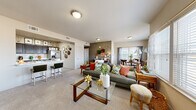 Located at 2400 Watermark Blvd in Oklahoma City, Oklahoma, this single-story, three-bedroom, two-bathroom residence offers a well-designed open-concept layout. The living and dining areas flow seamlessly together, featuring plush carpeting, neutral-toned walls, and large windows that invite abundant natural light and outdoor views. The living room provides a comfortable, spacious feel, while the adjacent dining area is brightened by a generous window arrangement framed by sheer curtains.

The kitchen is outfitted with dark cabinetry, light marble-style countertops, stainless steel appliances including a French door refrigerator, and wood-look tile flooring, creating a clean, modern aesthetic. A breakfast bar connects the kitchen to the living area for added convenience.

The primary bedroom is a well-proportioned retreat featuring carpet flooring, a ceiling fan, and a walk-in closet. The additional bedrooms are similarly appointed with carpet and ceiling fans, offering comfortable, functional spaces. Four closets throughout the unit provide ample storage.

The bathrooms feature wood-look tile flooring, dark vanity cabinetry with white countertops, large mirrors, and a tub-shower combination. Throughout the residence, the consistent use of neutral tones, natural light, and cohesive finishes creates a warm and inviting ambiance.