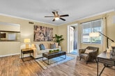 Located in Winchester, California, this single-story 2-bedroom, 2-bathroom residence offers a thoughtfully designed floor plan that maximizes comfort and functionality. The living room serves as the heart of the home, featuring wood-style flooring, crown molding, a ceiling fan, and a sliding glass door that invites natural light and provides access to an outdoor area. The adjacent kitchen is equipped with dark espresso cabinetry, a full suite of black appliances including a range, microwave, and refrigerator, a double-basin sink, and light countertops — all accented by the same wood-style flooring that flows throughout the main areas. The primary bedroom is a well-sized retreat with plush carpeting, a ceiling fan, and a walk-in closet outfitted with wire shelving for versatile storage. The second bedroom also features carpeting and a ceiling fan, offering a comfortable and functional space. Both bathrooms include a shower/tub combination, wood-style tile flooring, and dark vanity cabinetry with light countertops. A dedicated laundry room houses a full-size side-by-side washer and dryer. The hallway connects all areas seamlessly, completing a practical and inviting layout.