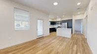 Located at 2525 S Meadows Rd in Santa Fe, NM, this single-story 2-bedroom, 2-bathroom home offers a clean, modern design with a thoughtfully laid-out floor plan. The open-concept living and kitchen area serves as the heart of the home, featuring warm wood-look flooring that runs throughout, recessed lighting, and bright windows that invite natural light. The kitchen is well-appointed with dark, flat-front cabinetry, white quartz countertops, a subway tile backsplash, a central island, and a full suite of stainless steel appliances including a refrigerator, electric range, microwave, and dishwasher. The spacious living area connects to a private patio through a glass door, extending the living space outdoors. Both bedrooms are comfortable and well-lit, each with a window and access to ample closet storage — three closets are distributed throughout the unit. The two bathrooms maintain the home's modern aesthetic, featuring dark vanity cabinetry, white countertops, and clean white shower surrounds — one with a walk-in shower and one with a tub/shower combo. A dedicated laundry area adds everyday convenience. The home's consistent use of neutral tones, modern finishes, and wood-look flooring creates a cohesive and welcoming atmosphere throughout.