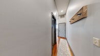 Located in the heart of Toledo, OH, this two-floor urban loft masterfully combines historic industrial character with contemporary design. The main floor opens into a spacious combined kitchen and living area, where warm hardwood floors and whitewashed exposed brick walls set a striking tone. The living room commands attention with its dramatic arched windows that flood the space with natural light and frame sweeping views of the Toledo skyline. The fully equipped kitchen features white shaker cabinetry, granite countertops, stainless steel appliances, and a bold red island with seating — a true centerpiece for entertaining. A staircase leads to the upper floor, where three bedrooms offer a mix of cozy and functional layouts, each accented by exposed brick and hardwood flooring. The primary bedroom features moody tones with an exposed ceiling and industrial-style details. The two bathrooms are thoughtfully finished — one with a granite-topped vanity and tub/shower combo, the other boasting a sleek marble-tiled walk-in shower with a rainfall showerhead. Throughout, the loft balances the raw beauty of its historic bones with polished modern updates, creating a truly distinctive urban retreat.