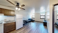 Located at 1720 S 29th St in Milwaukee, WI, this one-bedroom, one-bathroom unit offers a practical and well-organized layout across a single floor. Wood-look plank flooring flows consistently throughout the space, lending a clean, cohesive aesthetic.

The open living and dining area is bright and functional, featuring a ceiling fan with integrated lighting, baseboard heating, and multiple windows that bring in natural light and neighborhood views. The kitchen is positioned adjacent to the main living space and includes warm wood-toned cabinetry, a coil-burner electric range, and a full-size refrigerator, offering efficient use of the available space.

The bedroom is a comfortable, well-proportioned room with a large window overlooking greenery outside, baseboard heating, and an open closet for storage. The room's neutral walls and wood-look flooring keep the atmosphere clean and understated.

The bathroom features a combined tub and shower with a curtain enclosure, a toilet, and towel fixtures — all finished in a simple, neutral palette.

A hallway connects the rooms efficiently, contributing to the unit's straightforward and accessible layout. Throughout the space, natural light, neutral tones, and durable flooring create a practical living environment suited for everyday comfort.