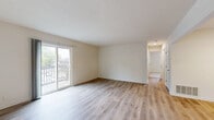 This single-floor, 2-bedroom, 1-bathroom residence offers a practical and comfortable layout designed to make efficient use of its space. The living room is a bright, open area featuring light wood-tone laminate flooring, neutral beige walls, a textured ceiling, and a sliding glass door that opens onto a private balcony with outdoor views — allowing natural light to fill the room. Adjacent to the living area, the dining room and kitchen provide a functional flow for daily living. The kitchen is equipped with stainless appliances, including an electric range and dishwasher, complemented by light wood flooring and clean white cabinetry. Both bedrooms feature soft wall-to-wall carpeting, ceiling fans with lighting, and windows with blinds that bring in natural light. The primary bedroom stands out with generous square footage and dual closets offering ample built-in shelving and hanging storage. The second bedroom also provides a comfortable, carpeted layout with its own ceiling fan. The full bathroom includes a tiled shower-tub combination with chrome fixtures and a clean, minimalist design. With five closets distributed throughout the unit, storage is a notable strength of this residence. A dedicated utility room rounds out the thoughtful and complete layout.