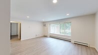 This thoughtfully designed 2-bedroom, 1-bathroom residence offers a clean, modern aesthetic across a single floor. Light-toned hardwood flooring runs throughout, lending a bright and cohesive feel to every room.

The spacious living room serves as the heart of the home, featuring recessed lighting, a wall-mounted air conditioning unit, baseboard heating, and a large picture window fitted with vertical blinds that frame outdoor greenery and fill the room with natural light.

The kitchen is fully updated and efficiently laid out, showcasing gray shaker-style cabinetry, light stone countertops, and a complete suite of stainless steel appliances including a refrigerator, range, microwave, and dishwasher. Light hardwood flooring continues seamlessly into this space.

Both bedrooms are comfortably sized with neutral painted walls, light hardwood floors, and ceiling fans with integrated lighting. The generously proportioned primary bedroom offers ample space for a variety of furniture arrangements.

The bathroom is finished to a high standard, featuring gray tile flooring, a tiled tub and shower surround, a granite-topped vanity with an undermount sink, and dark cabinetry with brushed nickel hardware. A connecting hallway ties all rooms together, completing this well-organized and move-in-ready home.