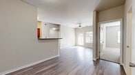 Located in Universal City, Texas, this single-story 2-bedroom, 2-bathroom home offers a well-designed layout with a comfortable, functional flow throughout. The open living area is anchored by wood-look plank flooring, neutral toned walls, and a ceiling fan, creating a bright and airy atmosphere. Large windows and a glass door at the front of the living room invite generous natural light, enhancing the sense of space.

The kitchen is equipped with warm wood cabinetry, dark granite-style countertops, black appliances including a refrigerator, electric range, microwave, and dishwasher, along with a subway tile backsplash. A peninsula breakfast bar connects the kitchen to the dining and living areas, making it ideal for casual dining and entertaining. An adjacent pantry provides additional storage.

The primary bedroom is generously proportioned, featuring plush carpeting, a ceiling fan, and a window that fills the room with natural light. The second bedroom mirrors this comfortable design. Both bathrooms include white cabinetry with dark countertops, framed mirrors, and tub-shower combinations with tile surrounds.

A central hallway connects the bedrooms, lined with multiple closets offering ample storage. The entrance provides a welcoming transition into the home, completing this well-appointed and practical floor plan.