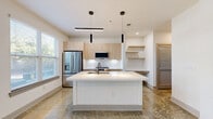 Located at 747 Ralph McGill Blvd NE in Atlanta's vibrant Old Fourth Ward neighborhood, this modern one-bedroom, one-bathroom residence offers a thoughtfully designed single-floor layout with contemporary finishes throughout. The open-concept kitchen and living area serves as the heart of the unit, anchored by a large center island with a white quartz countertop, an undermount sink, and a matte black faucet. Sleek pendant lighting hangs above the island, complementing the light wood cabinetry, subway tile backsplash, and stainless steel appliances including a French door refrigerator, electric range, and built-in microwave. Open floating shelves and a built-in desk area provide functional storage and workspace. Polished concrete floors extend throughout the main living areas, adding an industrial-modern character, while ceiling fans contribute to comfort. The bathroom features wood-look flooring, a light wood vanity with white countertop, and a tiled tub-shower combination with matte black fixtures and a built-in niche. A dedicated hallway leads to the bedroom and includes two closets for ample storage. Additional utility and laundry spaces round out the unit's practical amenities, making this a well-equipped and stylish urban residence.