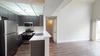 Located at 7009 Alvern St in the Westchester neighborhood of Los Angeles, this single-story residence offers a well-organized layout with a cohesive blend of modern finishes and functional design. The living area is a standout feature, boasting soaring vaulted ceilings, a distinctive circular window that draws in natural light, rich hardwood-style flooring, a fireplace, and sliding glass doors opening to a private balcony. A ceiling fan adds comfort to this generously proportioned space.

The kitchen is designed for practicality and style, featuring dark espresso cabinetry, white countertops, a peninsula with a built-in sink, and a full suite of stainless steel appliances including a gas range, microwave, and refrigerator. A mirrored ceiling panel above the kitchen enhances the sense of openness.

The bedrooms are carpeted for comfort, finished in neutral tones, and receive natural light through well-positioned windows. Closet storage is available with built-in shelving and hanging rods. The bathroom is appointed with a dark-framed vanity mirror, white countertop, dark wood-toned cabinetry, and a full soaking tub with shower. Hardwood-style flooring extends through the main living and kitchen areas, tying the space together with a warm, consistent aesthetic.