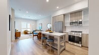 Located at 21010 Erwin St in the Woodland Hills neighborhood of Los Angeles, this thoughtfully designed one-bedroom, one-bathroom residence offers a refined modern living experience across a single well-organized floor. The open-concept kitchen and living area serves as the heart of the home, featuring light wood-tone cabinetry, white quartz countertops, stainless steel appliances including a gas range, built-in microwave, and dishwasher, and a central kitchen island with bar seating — ideal for casual dining or entertaining. Light hardwood flooring flows seamlessly throughout, complementing the clean, neutral palette and recessed lighting overhead. The living area is bright and welcoming, benefiting from large windows that invite natural light and provide views of the landscaped courtyard below via a private balcony. The bedroom is a calm retreat, featuring a generous window with outdoor views and easy access to the well-appointed bathroom, which includes a long wood-vanity with dual sinks, backlit mirrors, and large-format tile flooring. A dedicated walk-in closet offers organized storage. A hallway connects the spaces efficiently, completing this polished and functional urban residence.