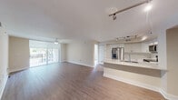 Located at 6460 Main Street in Miami Lakes, FL, this well-appointed 2-bedroom, 2-bathroom residence offers a thoughtfully designed single-floor layout. The open-concept living and kitchen area forms the heart of the home, featuring durable hardwood-style flooring, neutral tones, and a ceiling fan that enhances airflow and comfort. Sliding glass doors lead to a private balcony, flooding the living space with natural light and offering pleasant outdoor views.

The kitchen is equipped with stainless steel appliances — including a French door refrigerator, electric range, and over-the-range microwave — complemented by crisp white shaker cabinetry, a white subway tile backsplash, quartz countertops, and a peninsula with an undermount sink. Track lighting overhead adds both function and style.

The spacious primary bedroom features plush carpeting, a ceiling fan, a large window with outdoor views, and access to a generous walk-in closet with wire shelving. The second bedroom is similarly appointed with carpet and a ceiling fan. The primary bathroom includes a frameless glass walk-in shower with white subway tile. Two closets throughout the home provide ample storage. A connecting hallway ties all rooms together for a seamless, functional flow.