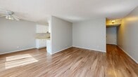 This single-floor, 1-bedroom, 1-bathroom unit offers a practical and comfortable layout thoughtfully designed to maximize its footprint. The open living area is finished with warm wood-look flooring and neutral light gray walls, creating a bright and inviting atmosphere. A ceiling fan adds functionality, while a large window dressed with sheer vertical blinds allows natural light to pour in, enhancing the sense of openness.

The kitchen is positioned adjacent to the living area and features white cabinetry, light-toned countertops, a stainless steel sink, and white appliances including a full-size refrigerator and stove. The consistent wood-look flooring extends into the kitchen, maintaining a cohesive aesthetic throughout the shared living spaces.

The bedroom is a well-sized, carpeted retreat finished with soft neutral tones and a textured ceiling. A large window with vertical blinds provides natural light and outdoor views, while mirrored sliding closet doors add both storage and a sense of expanded space. The room also provides direct access to the bathroom.

The bathroom is clean and bright, featuring a full-size soaking tub with white tile surround and a window for natural ventilation. Throughout the unit, a consistent use of white trim, neutral walls, and textured ceilings ties the design together into a cohesive, move-in-ready space.