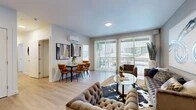 Located at 849 E Magnesium Rd in Spokane, WA, this 2-bedroom, 1-bathroom unit offers a well-designed, single-floor layout that maximizes both comfort and functionality. The open-concept living, dining, and kitchen area serves as the heart of the home, featuring light wood-style flooring that flows throughout. Large sliding glass doors flood the space with natural light and open to a private balcony, offering outdoor views. A wall-mounted mini-split system provides efficient climate control. The kitchen is outfitted with warm wood cabinetry, light quartz countertops, a glass tile backsplash, and stainless steel appliances including a refrigerator, dishwasher, and microwave. The dining area comfortably accommodates a full table and chairs beneath contemporary wall art. The primary bedroom includes a generously sized window with vertical blinds, offering ample natural light, while the second bedroom features a bold geometric accent wall and plush carpet. The bathroom presents a sleek wood-grain vanity with a wide mirror and white countertop, paired with a shower-tub combination. Two closets provide practical storage solutions, completing this thoughtfully arranged and modern living space.