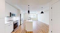 Located in Denver's sought-after West Highland neighborhood, this two-story home offers a thoughtfully designed layout across two floors. The main level features a generous open-concept kitchen and living area finished with warm light hardwood floors and crisp white walls. The kitchen is a standout, boasting a large central island with an undermount sink and matte black faucet, sleek flat-front white cabinetry, stainless steel appliances, and striking black pendant lighting that anchors the space with modern contrast. The living area flows seamlessly from the kitchen, bathed in natural light from a large window.

Upstairs, two well-proportioned bedrooms are finished with plush carpet and feature ample natural light. The primary bedroom includes access to dedicated closets and a private en suite bathroom complete with a double vanity, white quartz countertops, matte black fixtures, hexagonal tile flooring, and a tiled walk-in shower. A second full bathroom mirrors the same refined aesthetic. The lower level provides additional flexible space, accessible via carpeted stairs with clean white walls and modern black door hardware consistent throughout the home. With three bathrooms total and two closets, this home balances comfort and contemporary style seamlessly.