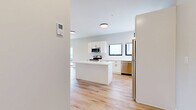 Located at 27S Main St in Attleboro, MA, this thoughtfully designed one-bedroom, one-bathroom unit offers a clean, modern aesthetic across a single floor. Light-toned hardwood flooring runs throughout the entire space, creating a bright and cohesive feel from room to room.

The heart of the unit is the open-concept kitchen, dining, and living area. The kitchen is a standout feature, boasting white shaker-style cabinetry with matte black hardware, a marble-look quartz center island, white subway tile backsplash, and a full suite of stainless steel appliances including a range, microwave, dishwasher, and refrigerator. Multiple windows invite abundant natural light into the space.

The living area is generously proportioned and includes a large sliding glass door that opens to an outdoor view of the surrounding greenery, enhancing the sense of openness. The bedroom is a comfortable and well-lit retreat with dual windows framing outdoor views and two closets providing ample storage. The bathroom features a clean, all-white tub and shower surround with chrome fixtures. A dedicated utility room and additional storage complete the functional layout of this move-in ready unit.
