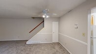Located at 9640 Fernwood Drive in Olmsted Falls, Ohio, this two-story home offers a functional and straightforward layout spread evenly across two floors. The main level features a spacious living room with plush carpeting, neutral walls, a ceiling fan with integrated lighting, and a staircase with a warm wood railing leading to the upper level. A window on this floor allows natural light to filter in, while a nearby entry door provides convenient access. The kitchen is well-equipped with warm oak cabinetry, granite-style countertops, a double stainless steel sink, light wood-style vinyl flooring, and white appliances including a gas range and refrigerator. A window overlooking greenery brightens the space. A dedicated utility room off the kitchen houses mechanical systems. The full bathroom features a granite-style vanity with oak cabinetry, a large mirror, and tile-surround tub area with wood-style flooring. Upstairs, three carpeted bedrooms offer comfortable retreats, including a generously sized primary bedroom. Each bedroom benefits from neutral tones and natural light, with the primary bedroom featuring a window framing scenic autumn foliage views. A hallway connects the upper-level rooms. Throughout, the home maintains a clean, move-in ready aesthetic with consistent neutral tones.