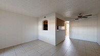 Located at 1108 E Highland Ave in Phoenix, AZ, this well-organized one-bedroom, one-bathroom unit offers a practical and comfortable single-floor layout. Light-toned ceramic tile flooring runs throughout the entire space, providing a clean, cohesive look that is easy to maintain in Arizona's warm climate.

The open living area is bright and airy, featuring a textured ceiling, a ceiling fan with light fixture, and a sliding glass door that invites natural light and provides access to an outdoor area. A secondary entry door adds convenience to the layout.

The kitchen is partially separated from the living area by a half-wall breakfast bar, creating an open yet defined cooking space. It features warm wood-toned cabinetry extending to the ceiling for ample storage, black appliances including a range and refrigerator, light countertops, and a charming arched pass-through window connecting to the living room.

The spacious bedroom is equipped with a ceiling fan, a window for natural light, direct access to an outdoor area via a sliding glass door, and a wide mirrored sliding-door closet that enhances the sense of space.

The full bathroom includes a vanity with wood cabinetry, a toilet, and a tub-shower combination, finished with matching tile flooring for consistency throughout the home.
