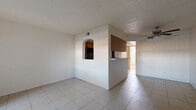 Located at 1108 E Highland Ave in Phoenix, AZ, this well-organized one-bedroom, one-bathroom unit offers a practical and comfortable single-floor layout. Light-toned ceramic tile flooring runs throughout the entire space, providing a clean, cohesive look that is easy to maintain in Arizona's warm climate.

The open living area is bright and airy, featuring a textured ceiling, a ceiling fan with light fixture, and a sliding glass door that invites natural light and provides access to an outdoor area. A secondary entry door adds convenience to the layout.

The kitchen is partially separated from the living area by a half-wall breakfast bar, creating an open yet defined cooking space. It features warm wood-toned cabinetry extending to the ceiling for ample storage, black appliances including a range and refrigerator, light countertops, and a charming arched pass-through window connecting to the living room.

The spacious bedroom is equipped with a ceiling fan, a window for natural light, direct access to an outdoor area via a sliding glass door, and a wide mirrored sliding-door closet that enhances the sense of space.

The full bathroom includes a vanity with wood cabinetry, a toilet, and a tub-shower combination, finished with matching tile flooring for consistency throughout the home.