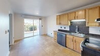 Located at 10625 22nd Pl S in Seattle, WA, this 2-bedroom, 1-bathroom unit offers a practical and well-organized single-floor layout. The kitchen is equipped with warm honey-toned cabinetry, dark granite countertops, a dark tile backsplash, and stainless steel appliances including a range and dishwasher. Tile flooring ties the kitchen and adjacent living area together, and a sliding glass door opens directly to a private patio with greenery views, filling the space with natural light. The living room provides a comfortable, open feel with easy access to the rest of the unit. A central hallway connects the main living areas to the two bedrooms and shared bathroom, featuring light hardwood-style flooring. Both bedrooms are carpeted and offer windows with natural light; one overlooks natural rock formations, while the other enjoys views of the surrounding neighborhood. The primary bedroom includes a large sliding-door closet. The bathroom features a full tub-shower combination, hardwood-style flooring, and a vanity with white countertop and rich wood cabinetry. Five closets throughout the unit ensure ample storage. Baseboard heating is present throughout.