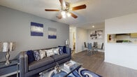 This single-floor residence offers a thoughtfully designed layout that balances comfort and functionality throughout. The open-concept living and dining area serves as the heart of the home, featuring wood-look flooring, a textured ceiling with a ceiling fan and light fixture, and a sliding glass door that invites natural light and provides access to an outdoor space. The living area flows seamlessly into a dedicated dining space, making it well-suited for everyday living and entertaining.

The galley-style kitchen is efficiently organized with gray cabinetry lining both walls, white countertops, and black appliances including a refrigerator, electric range, and dishwasher. A stainless steel sink is positioned beneath a window, and a doorway at the end of the kitchen connects to the rest of the unit.

The bathroom is clean and functional, featuring a tub-shower combination, a gray vanity with a light countertop, and wood-look flooring that continues the design language of the common areas.

The bedrooms are carpeted and generously proportioned. The primary bedroom includes multiple windows that allow for ample natural light, a walk-in closet, and an en-suite layout. A second bedroom also features a closet and access to an additional room. Throughout the residence, a neutral color palette with gray and white tones creates a cohesive and inviting atmosphere.