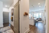 This thoughtfully designed single-floor residence combines modern aesthetics with functional living. The open-concept layout connects the kitchen, dining, and living areas seamlessly, all finished with warm hardwood-style flooring throughout. The kitchen is a standout feature, equipped with full stainless steel appliances, crisp white shaker cabinetry, granite countertops, a striking blue subway tile backsplash, and a waterfall-edge island with pendant lighting above — ideal for both cooking and casual dining. The dining area offers direct access to a private balcony through a sliding glass door, bringing in natural light and outdoor views. The living room benefits from multiple windows fitted with blinds, recessed lighting, and a bright, airy atmosphere. The primary bedroom is generously proportioned with plush carpet, large windows, and a private sliding door to an outdoor balcony. A spacious walk-in closet with built-in wire shelving provides ample storage. The bathroom features granite countertops, an undermount sink, and a clean, contemporary vanity. Throughout the residence, white walls, clean lines, and recessed lighting create a cohesive, modern ambiance that is both inviting and functional.