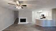 Located at 4447 Rainier St in Irving, TX, this two-story, 2-bedroom, 2-bathroom home is thoughtfully laid out across two well-proportioned floors. The ground floor hosts an open-concept living, dining, and kitchen area, anchored by a classic fireplace and complemented by a ceiling fan with light fixture overhead. Wood-look flooring runs throughout, adding warmth and continuity to the space. The kitchen features white cabinetry with modern hardware, a black appliance suite including an electric range, over-the-range microwave, and refrigerator, along with light countertops and a stainless steel sink. A conveniently located half bathroom is also found on this level. Upstairs, two bedrooms offer comfortable retreats, each with wood-look floors, neutral walls, and natural light from windows fitted with blinds. The primary bedroom is generously sized with direct access to a full bathroom and a dedicated closet. A second full bathroom with vanity and storage serves the remaining bedroom. Additional highlights include an in-unit laundry area, a private balcony, a ground-level patio, and ample closet space — making this home a well-equipped and functional residence.