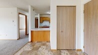 Located at 319 Laudenbach Ct in Saint Cloud, Minnesota, this single-floor unit offers a well-organized layout designed for comfortable everyday living. The kitchen is a standout feature, offering generous cabinetry in warm oak tones, ample counter space, a double-basin sink, and white appliances including a range, refrigerator, and dishwasher. Stone-look tile flooring runs through the kitchen and entry areas, providing a durable and easy-to-maintain surface. The open layout connects the kitchen to the living and dining areas through a convenient pass-through counter, creating an inclusive, connected feel. The living area is carpeted and bright, benefiting from natural light and access to a balcony through a sliding glass door that frames scenic outdoor views. The bedroom is a comfortable, carpeted space with its own window overlooking the surrounding landscape and includes a generously sized double-door closet for ample storage. The full bathroom is well-appointed with warm wood vanity cabinetry, a combined tub and shower, and the same stone-look tile flooring found throughout the common areas. Baseboard heating is present throughout, and the textured ceilings add a classic residential character to the space overall.