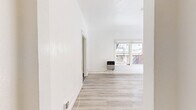 Located at 4364 W 3rd St in Los Angeles, CA, this single-floor unit offers a thoughtfully arranged layout comprising a living room, kitchen, bathroom, closet, and entrance. The living room serves as the centerpiece of the space, showcasing a striking exposed brick accent wall with a charming arched window detail that floods the room with natural light. Light-toned hardwood-style flooring runs throughout, complementing the crisp white walls and creating a bright, airy atmosphere. A ceiling fan adds both function and style overhead, while a wall-mounted heater provides practical comfort. The kitchen features large-format grey tile flooring, white cabinetry, a stainless steel refrigerator, and a window that continues the natural light theme throughout the unit. The bathroom is a standout with its bold black-and-white patterned encaustic-style tile flooring, a white vanity with brass hardware fixtures, and clean white walls that give it a stylish yet timeless feel. The entrance offers a welcoming transition into the space, and the dedicated closet provides convenient storage. Overall, the unit balances historic architectural charm — most notably through its exposed brick detailing — with clean, contemporary finishes throughout.