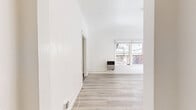 Located at 4364 W 3rd St in Los Angeles, CA, this single-floor unit offers a thoughtfully arranged layout comprising a living room, kitchen, bathroom, closet, and entrance. The living room serves as the centerpiece of the space, showcasing a striking exposed brick accent wall with a charming arched window detail that floods the room with natural light. Light-toned hardwood-style flooring runs throughout, complementing the crisp white walls and creating a bright, airy atmosphere. A ceiling fan adds both function and style overhead, while a wall-mounted heater provides practical comfort. The kitchen features large-format grey tile flooring, white cabinetry, a stainless steel refrigerator, and a window that continues the natural light theme throughout the unit. The bathroom is a standout with its bold black-and-white patterned encaustic-style tile flooring, a white vanity with brass hardware fixtures, and clean white walls that give it a stylish yet timeless feel. The entrance offers a welcoming transition into the space, and the dedicated closet provides convenient storage. Overall, the unit balances historic architectural charm — most notably through its exposed brick detailing — with clean, contemporary finishes throughout.