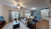 Located at 8200 Micron Drive in San Antonio, Texas, this single-floor residence offers a thoughtfully designed layout with cohesive styling throughout. The living room is a welcoming focal point, featuring crown molding, a ceiling fan with light fixture, warm wood-look flooring, and multiple windows dressed with gray curtain panels that invite natural light. The space flows seamlessly into the dining area, which is distinguished by a striking teal accent wall and a sliding glass door that opens to an outdoor view, enhancing the sense of openness.

The kitchen is functionally equipped with warm wood cabinetry, dark countertops, a mosaic tile backsplash, and black appliances including a refrigerator, range, and built-in microwave, all set atop matching wood-look flooring.

The bedroom offers a calm retreat with carpeted floors, a warm-toned accent wall, and ample space for furnishings. The bathroom features wood-look flooring, a vanity with dark countertop, and a tub-shower combination, with direct access to a spacious walk-in closet complete with built-in shelving and hanging rods.

Crown molding is carried throughout the main living spaces, lending a polished, consistent finish to this well-maintained San Antonio residence.