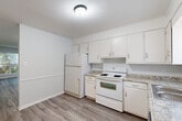 Located on Blair Street in Thomasville, NC, this two-floor home offers a practical and well-organized layout spread across two levels. The main floor provides the larger share of the living space and features a bright kitchen equipped with white cabinetry, granite-style countertops, a stainless steel dishwasher, electric range, and full-size refrigerator. Light wood-style flooring runs throughout the main level, complementing the clean, neutral color palette. A pantry offers additional storage, and a hallway connects the main areas seamlessly. A staircase with a classic white balustrade leads to the upper level, which houses the private bedroom. The bedroom is carpeted for comfort, features a ceiling fan, a dedicated closet with shelving, and a window that allows natural light to filter in. Two bathrooms serve the home — one on each floor — both featuring white vanities and distinctive yellow tile backsplashes that add a retro character. The upper bathroom includes a tiled shower/tub surround and connects conveniently to the hallway near the staircase landing. Throughout the home, textured ceilings, white trim, and light-toned walls create a cohesive and clean aesthetic. This home delivers efficient, functional living across its two thoughtfully arranged floors.