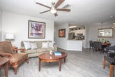 This single-floor, two-bedroom, two-bathroom residence at 2035 Timothy Road in Athens, Georgia offers a thoughtfully designed layout with consistent, modern finishes throughout. The spacious living room is a central highlight, featuring light hardwood-style flooring, a ceiling fan, and a large bay window that fills the space with natural light and provides outdoor views. The room comfortably accommodates a seating area and flows naturally into the adjacent dining space, which is accented by a pendant light fixture and chair rail molding along the walls.

The kitchen is equipped with white shaker-style cabinetry, granite countertops, and stainless steel appliances, with direct access to a dedicated laundry room for added convenience. Both bedrooms are generously sized, each featuring plush carpet flooring, ceiling fans, and windows with blinds that allow for controlled natural light. The primary bedroom includes a closet with double doors.

Each bathroom mirrors the home's refined aesthetic, showcasing granite vanity countertops, white cabinetry, large mirrors, and wood-look tile flooring. One bathroom features a shower-tub combination with grab bars, indicating accessibility-conscious design. The neutral gray and white color palette maintained throughout the residence creates a cohesive, calm ambiance.