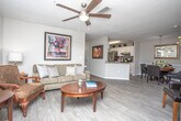This single-floor, two-bedroom, two-bathroom residence at 2035 Timothy Road in Athens, Georgia offers a thoughtfully designed layout with consistent, modern finishes throughout. The spacious living room is a central highlight, featuring light hardwood-style flooring, a ceiling fan, and a large bay window that fills the space with natural light and provides outdoor views. The room comfortably accommodates a seating area and flows naturally into the adjacent dining space, which is accented by a pendant light fixture and chair rail molding along the walls.

The kitchen is equipped with white shaker-style cabinetry, granite countertops, and stainless steel appliances, with direct access to a dedicated laundry room for added convenience. Both bedrooms are generously sized, each featuring plush carpet flooring, ceiling fans, and windows with blinds that allow for controlled natural light. The primary bedroom includes a closet with double doors.

Each bathroom mirrors the home's refined aesthetic, showcasing granite vanity countertops, white cabinetry, large mirrors, and wood-look tile flooring. One bathroom features a shower-tub combination with grab bars, indicating accessibility-conscious design. The neutral gray and white color palette maintained throughout the residence creates a cohesive, calm ambiance.
