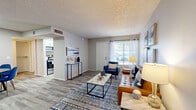 Located on E Speedway Blvd in Tucson, Arizona, this 2-bedroom, 1-bathroom unit offers a thoughtfully arranged single-floor layout that maximizes its compact footprint. The entry foyer welcomes you with wood-look flooring and neutral gray walls, setting a clean, modern tone throughout.

The open-concept living and dining area is bright and inviting, with natural light streaming through a window dressed with sheer curtains and blinds. Wood-look flooring, a textured ceiling, and a front-facing entry door contribute to a cohesive, functional design. The galley-style kitchen is efficiently organized with white cabinetry, light countertops, stainless steel appliances including a range, microwave, refrigerator, and dishwasher, plus a window that brings in additional natural light.

The primary bedroom is a comfortable retreat, featuring plush carpeting, a window with blinds, and access to a dedicated walk-in closet. The second bedroom, also carpeted, offers a similarly restful atmosphere with clean walls and ample space. The bathroom is well-appointed with a white vanity, dual mirrors, modern lighting, and a tub-shower combination with tile-look flooring. Throughout the unit, a consistent palette of soft grays and whites creates a calm, move-in-ready environment.