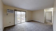 Located at 1420 Pennsylvania Ave in Des Moines, Iowa, this two-bedroom, one-bathroom unit offers a practical and comfortable single-floor layout. The living room is a bright, open space anchored by a sliding glass door that leads to a balcony, offering outdoor views and filling the room with natural light. Baseboard heating and a wall-mounted air conditioning unit ensure year-round climate control. Neutral-toned carpet runs throughout the living areas and bedrooms, creating a cohesive feel. The kitchen features wood-style flooring, providing a clean contrast to the carpeted spaces, and connects easily to the rest of the unit. The primary bedroom is a comfortable size with its own closet and convenient access to the full bathroom, which includes a soaking tub and shower combination, wood-style tile flooring, and a vanity. The second bedroom is similarly sized, featuring carpet, a ceiling fan, a window with natural light, and its own closet. With four closets total throughout the unit, storage is plentiful. The layout is straightforward and efficient, making practical use of the available space throughout the entire unit.
